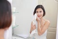 Young asian woman wiping her face with towel in bathroom Royalty Free Stock Photo