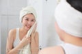 Young asian woman wiping her face with towel in bathroom Royalty Free Stock Photo