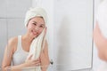 Young asian woman wiping her face with towel in bathroom. Royalty Free Stock Photo