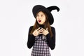 Young asian woman in witch halloween costume with hat standing and fear or surprised over white background Royalty Free Stock Photo