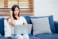 Young asian woman work on laptop computer on sofa at home with frustrated and bored. Royalty Free Stock Photo