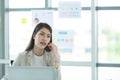 Young asian woman working at a call center Consulting about stock investment information with customers calling Royalty Free Stock Photo