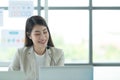 Young asian woman working at a call center Consulting about stock investment information with customers calling for advice Royalty Free Stock Photo