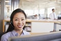 Young Asian woman working in a call centre smiling to camera Royalty Free Stock Photo