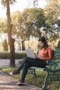 Young asian woman working with her laptop on about her online business bench in the park outdoors on vacation time Royalty Free Stock Photo