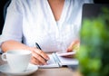 Young Asian woman working from home a hand holding pencil writing agenda note with smartphone, office desk background, Checklist N Royalty Free Stock Photo