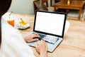 Young Asian woman working on laptop in coffee shop on weekend. Technology and lifestyle, work from home, 5G concept. Copy space Royalty Free Stock Photo