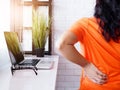 Asian woman working with laptop computer and sitting on chair and suffering low spine back pain and waist sore, Health Royalty Free Stock Photo