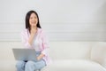 Young asian woman working on laptop computer sitting on sofa in the living room at home. Royalty Free Stock Photo