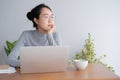 Young asian woman working on laptop in the home office desk. And sit at table resting chin on hand Royalty Free Stock Photo