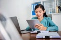 Young asian woman working on laptop and tablet financial working at home concept Royalty Free Stock Photo