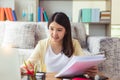 Young asian woman working on notebook computer and holding document at home. Beautiful businesswoman working on laptop computer Royalty Free Stock Photo