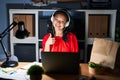Young asian woman working at the office with laptop at night doing happy thumbs up gesture with hand Royalty Free Stock Photo