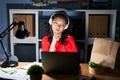 Young asian woman working at the office with laptop at night looking confident at the camera with smile with crossed arms and hand Royalty Free Stock Photo