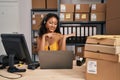 Young asian woman working at small business ecommerce wearing headset amazed and smiling to the camera while presenting with hand Royalty Free Stock Photo