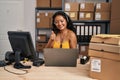 Young asian woman working at small business ecommerce wearing headset smiling happy and positive, thumb up doing excellent and Royalty Free Stock Photo