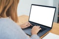 Young Asian woman working using and typing on laptop with mock up blank white screen while at home in office work space. Royalty Free Stock Photo