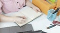 Young Asian woman is writing down the customer`s details and addresses on the Clipboard in order to prepare. Royalty Free Stock Photo