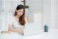 Young asian woman writing on notebook for planning working and using laptop computer on desk at home. Royalty Free Stock Photo