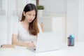 Young asian woman writing on notebook for planning working and using laptop computer on desk at home. Royalty Free Stock Photo