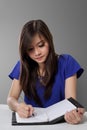 Young Asian woman writing on notebook Royalty Free Stock Photo