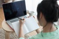 Young Asian woman writing on notebook