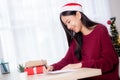 Young asian woman writing postcard in Christmas day at home, eve and celebrate, female writing message on greeting card.