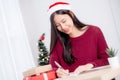 Young asian woman writing postcard in Christmas day at home, eve and celebrate, female writing message.