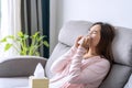 Young asian women with allergies feeling unwell using tissues and sneezing