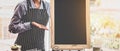 Young asian women barista with blank chalkboard menu in coffee shop Royalty Free Stock Photo