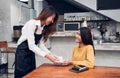 Young asian woman barista hold coffee cup serving a client at the coffee shop,start up small business owner food and drink concept Royalty Free Stock Photo