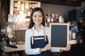 Young asian women barista holding blank chalkboard menu in coffee shop Royalty Free Stock Photo