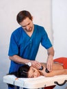 Young Asian woman enjoying the therapeutic effects of a traditional hot stone massage at luxury spa and wellness center Royalty Free Stock Photo