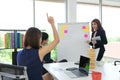 Young Asian woman raising hands and asking a question during presentation in conference room Royalty Free Stock Photo