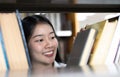 Young Asian women are searching for books in the university`s great library Royalty Free Stock Photo