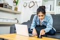 Young Asian women sit on the sofa to work at home. Looking for information on laptops and mobile phones to get the job done Royalty Free Stock Photo