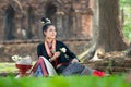 Young Asian women in Traditional dress sit on green grass with pillow hand hold white lotus.Beautiful girls in traditional costume Royalty Free Stock Photo