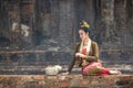 Young Asian women in Traditional dress sit on old wall look and silver bow ot lotus.Beautiful girls in traditional costume.Thai Royalty Free Stock Photo