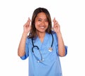Young asiatic nurse woman crossing her fingers
