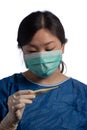 Young asiatic physician woman wearing a protection mask with medical gloves reading a thermometer reading temperature on a