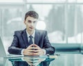 Young aspiring businessman sitting at a Desk before an open lapt