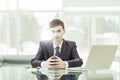 Young aspiring businessman sitting at a Desk before an open laptop