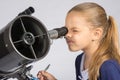 The young astronomer looks through the eyepiece of the telescope and record results