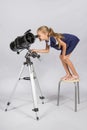 The young astronomer standing on a chair and funny looking in a telescope eyepiece Royalty Free Stock Photo