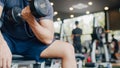 Young athlete Asian guy exercising doing lifting dumbbell fat burning workout in fitness class. Sportsman recreational activity, Royalty Free Stock Photo