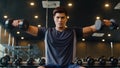 Young athlete Asian guy exercising doing lifting dumbbell fat burning workout in fitness class. Sportsman recreational activity, Royalty Free Stock Photo