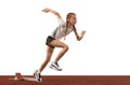 Young athlete, beginner female track runner bursting off starting block isolated over white background. Sport, workout Royalty Free Stock Photo
