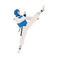 A young athlete in a blue vest and a protective helmet on his head makes a kick in the martial arts of taekwondo
