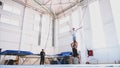 An young athlete is doing an air back flip on safety slings in the gym. Royalty Free Stock Photo