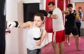 Young athlete female is beating a boxing bag